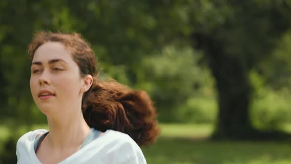 Sport activity. A young pretty caucasian woman ties her shoelaces and starts jogging