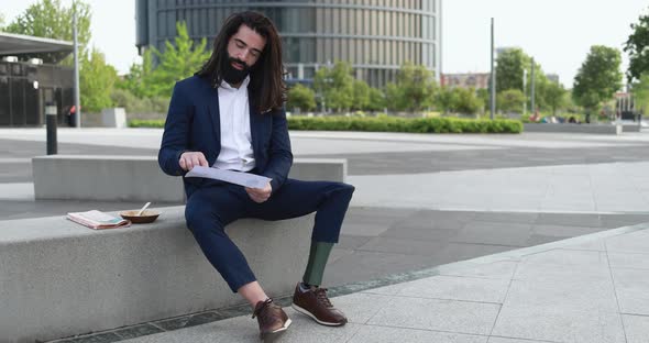 Business man with prosthetic leg working outdoor from office building - Job and insurance concept