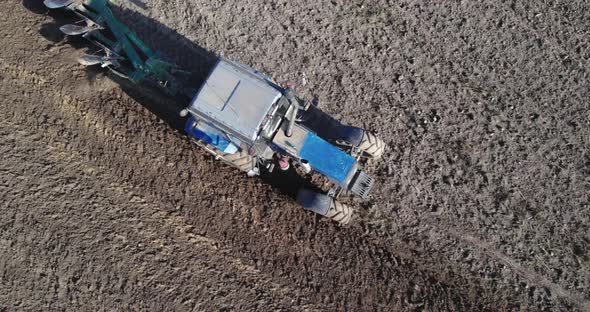 Tractor with a Plow Processes the Soil in Season