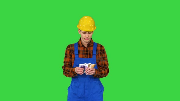 A Workman Counting Cash in Exaggerated Way and Dancing After That on a Green Screen, Chroma Key