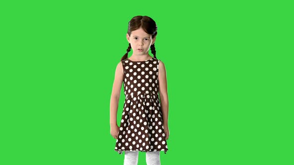 Cute Little Girl in Polka Dot Dress Talking About Something To the Camera on a Green Screen Chroma