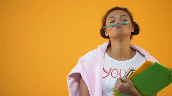 Playful African American Student Having Fun Holding Pencil With Lips, College