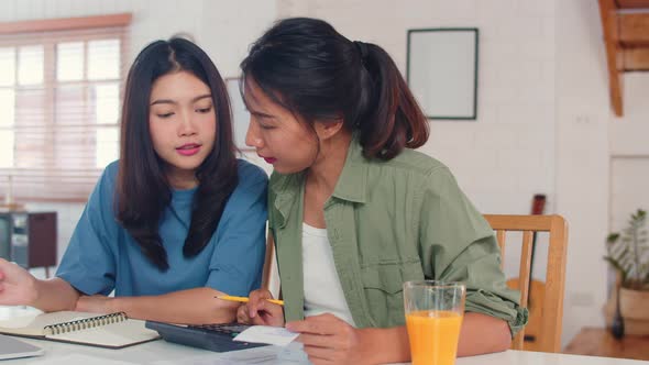 Business Asian Lesbian lgbtq women couple do account at home.