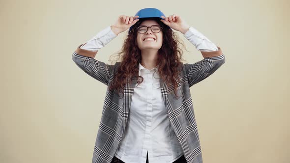 The Young Engineer with Curly Hair Puts a Special Helmet on Her Eyes and Smiles with Her Teeth Out