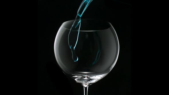 Pouring blue water into glass, Slow Motion