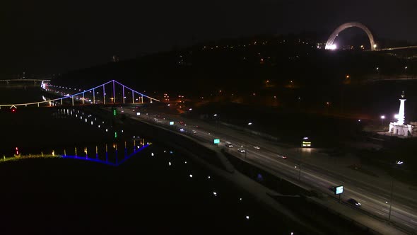 Pedestrian Bridge in Kiev. Evening Lighting. Reflection of the Bridge in the River Aerial View