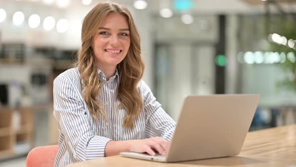 Cheerful Businesswoman with Laptop Smiling at Camera 