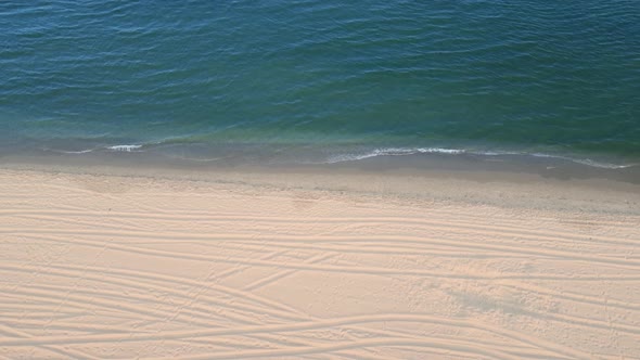 Aerial View of Beach with Shade Emerald Blue Water and Wave Foam on Tropical Sea