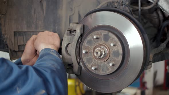 Mechanic Repairing Brake Discs in a Car Vehicle