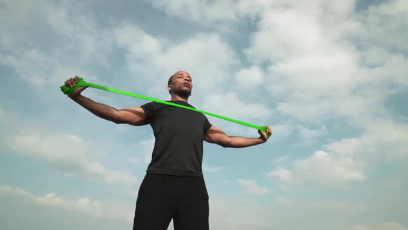 Handsome African Guy Using Power Band for Strength Training