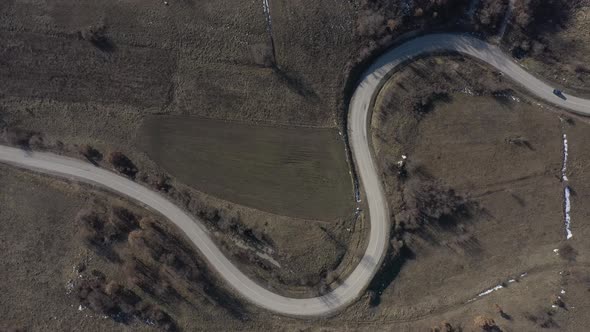 Vehicles on curvy road over the hill 4K drone video