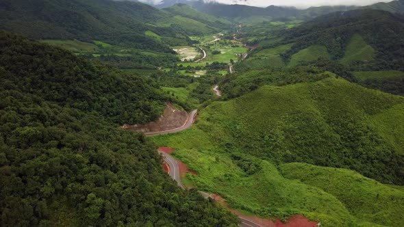 Logistic concept aerial view of countryside road - motorway passing through the serene lush greenery