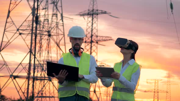 Outdoors ETL with Two Technicians Working with Computers Using VR Headset.