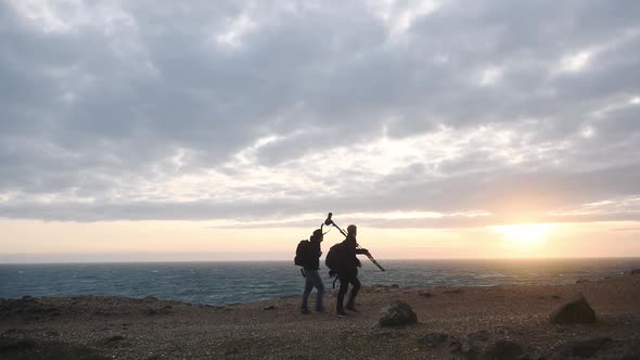 A Couple Of Landscape Photographers takings photos on the Jurassic Coast in Dorset, Carrying Cameras