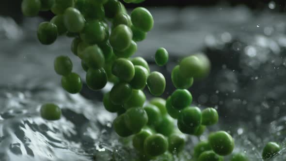 Throwing green peas into boiling water. Slow Motion.