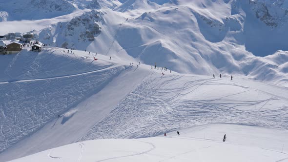 Many Skiers And Snowboarders Sliding Down Ski Slope In Snowy Mountains In Winter