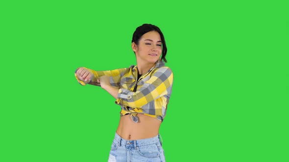 Girl in Square Shirt and Jeans Shorts, Sneakers, Dancing on a Green Screen, Chroma Key.