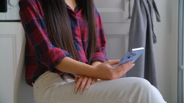 Asian girl using modern smart phone to browse internet news feed