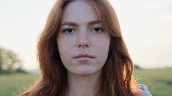 Charming Female Ginger Face with Freckles on Nature at Sunset