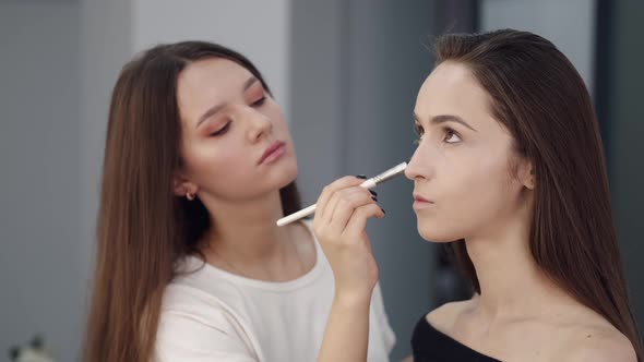 Portrait of Makeup Artist and Client While Doing Makeup