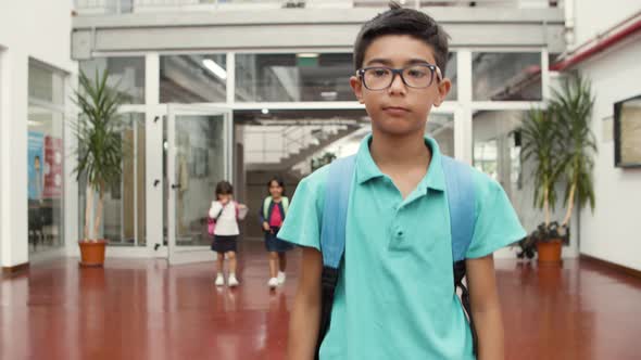 Medium Shot of Smiling Boy in Eyeglasses Walking in School