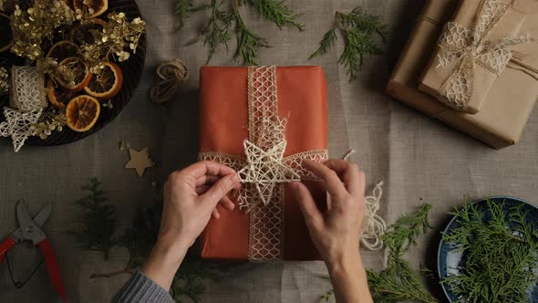 Female Hands Decorating Christmas Gift Box