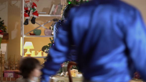 Smiling Beautiful Caucasian Woman with Christmas Bread Inviting Middle Eastern Family at New Year