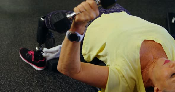 Senior woman doing chest press workout with dumbbell