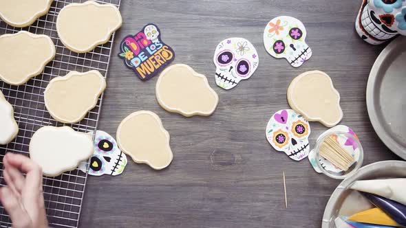 Step by step. Flat lay. Flooding a sugar skull cookie with white royal icing.