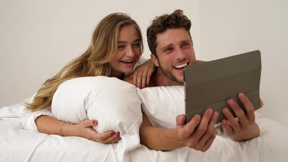 Couple with Tablet in Bed