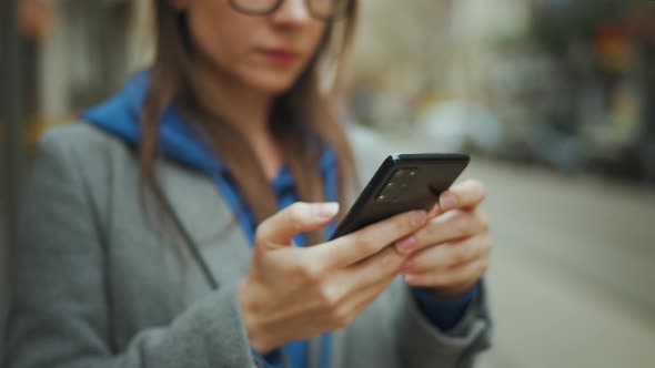 Woman Stands at a Public Transport Stop and Checks the Timetable