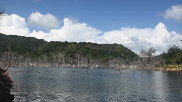 Timelapse video. The Clouds move over the tropical forest mountain and below it freshwater lake with