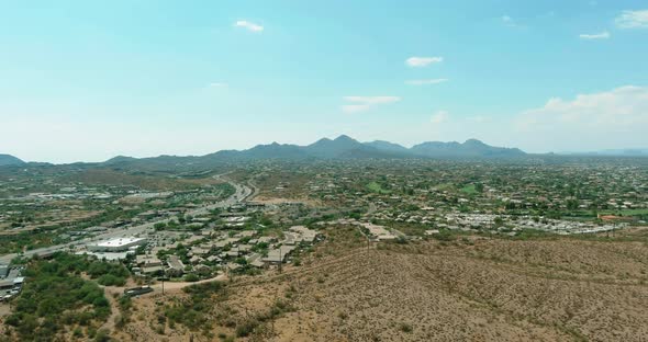 Flight with a Drone Over a with Low Houses in Small Fountain Hills Town Near Mountain Desert a Sunny