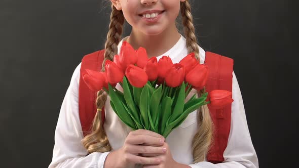 Schoolgirl With Rucksack Holding Bunch of Tulips, Teachers Day Celebration