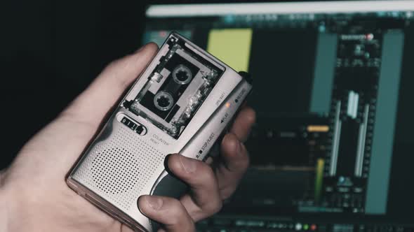 Portable Tape Recorder in Hand Records Sound or Interviews on a Mini Cassette