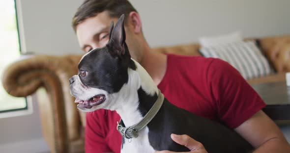 Caucasian man is playing with his dog at home