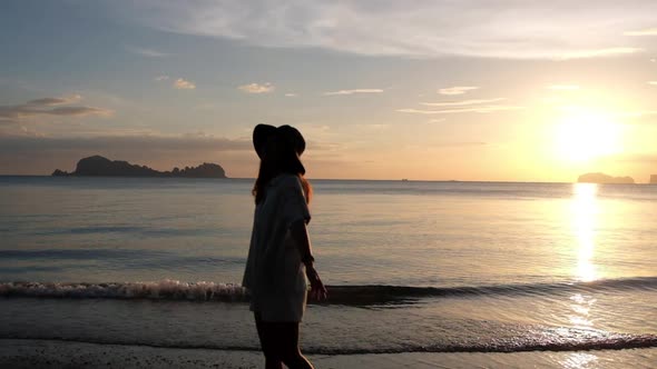 Silhouette blurred slow motion of a woman walking on the beach before sunset