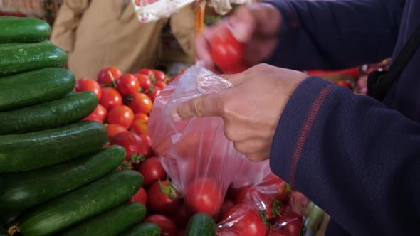 Faceless Person Puts Vegetables in Bag on Market