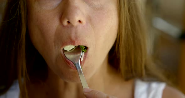 Vegetarian Woman Is Putting Leaf of Lettuce in Her Mouth By Fork and Chewing