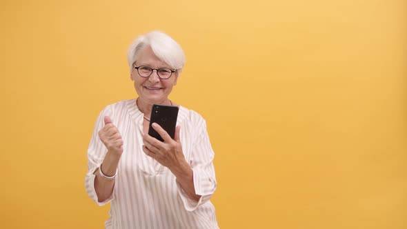 Happy Senior Lady Dancing with Smartphone