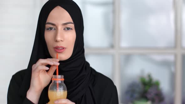 Portrait Cute Asian Woman in Hijab Drinking Orange Juice From Bottle Use Straw