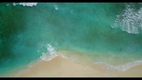 Aerial panorama of idyllic seashore beach break by blue ocean with bright sandy background of a dayo