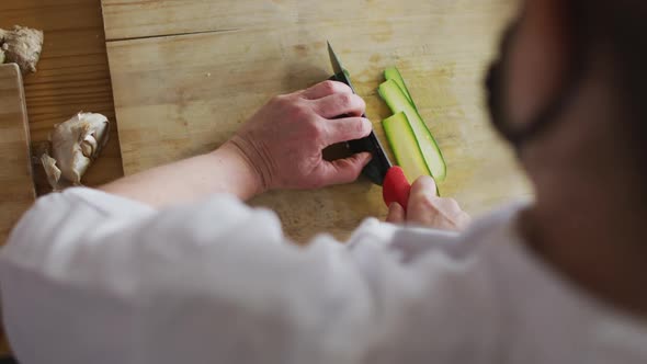 Caucasian female chef cutting zucchini