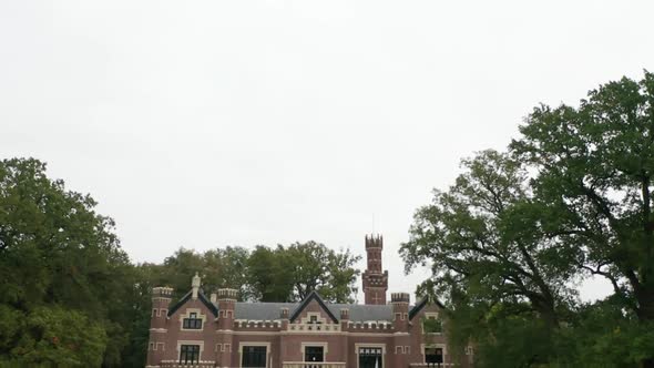 Tilting down from cloudy sky while flying towards Schaffelaar Castle in Barneveld, the Netherlands