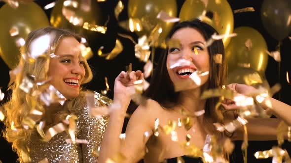 Smiling Women Dancing and Having Fun at Night Club Under Falling Confetti