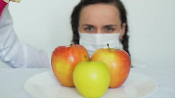 Female Spraying GMO Apples with Chemicals