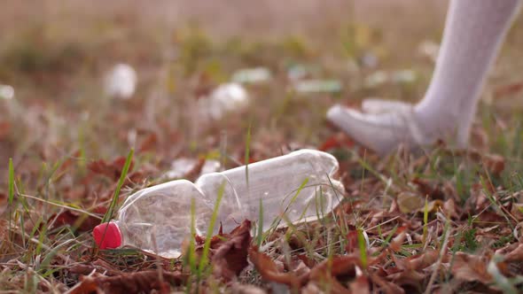 Woman Picking Up Plastic Bottle