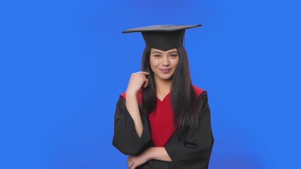 Portrait of Female Student in Cap and Gown Graduation Flirtatiously Smiles Shows Call Me