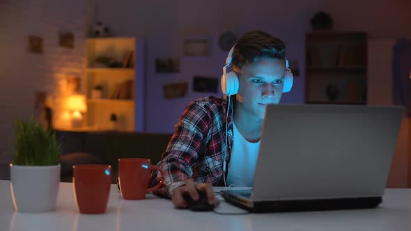 Extremely Anxious Teenager Playing Computer Game on Laptop Uncontrolled Emotions