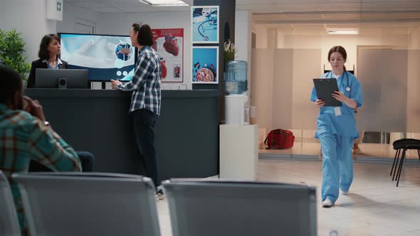 Medical Assistant Asking African American Man to Attend Consultation